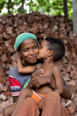 İşçi bir anne, Bangladeş 'te, Dhaka' da çocuklarının iş yerinde öpüşürken eğleniyor. 13 Mayıs 2017