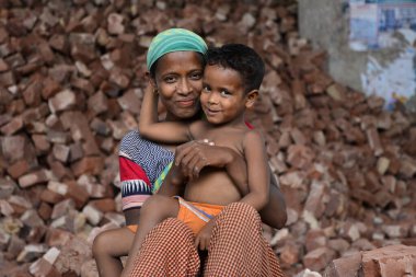 İşçi bir anne, Bangladeş 'te, Dhaka' da çocuklarının iş yerinde öpüşürken eğleniyor. 13 Mayıs 2017
