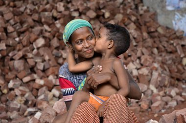 İşçi bir anne, Bangladeş 'te, Dhaka' da çocuklarının iş yerinde öpüşürken eğleniyor. 13 Mayıs 2017