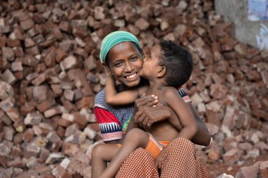 İşçi bir anne, Bangladeş 'te, Dhaka' da çocuklarının iş yerinde öpüşürken eğleniyor. 13 Mayıs 2017