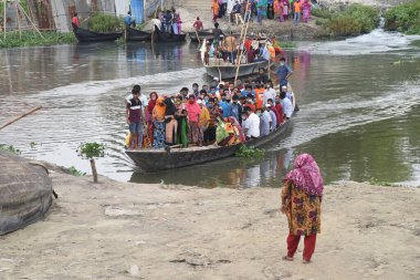 3 Mayıs 2020 'de Bangladeş' in Dhaka kentindeki COVID-19 koronavirüsüne karşı tedbir olarak hükümet tarafından tecrit altına alınırken, giysi işçileri sokakta yürürken yüz maskesi takıyorlar..