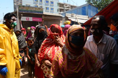 Bangladeşli fakirler, 29 Mart 2020 'de Bangladeş' in Dhaka kentindeki COVID-19 koronavirüsüne karşı önleyici tedbir olarak hükümet tarafından kapatılırken özel bir örgüt tarafından gıda dağıtımını toplamak için sırada bekliyorlar.