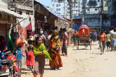Bangladeş gecekondu halkı, 29 Mart 2020 'de Bangladeş' in Dhaka kentindeki COVID-19 coronavirüsüne karşı önleyici bir tedbir olarak hükümet tarafından uygulanan tecrit sırasında gecekondu mahallesinde yürüyor.