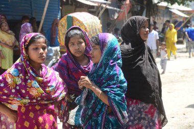 Bangladeş gecekondu halkı, 29 Mart 2020 'de Bangladeş' in Dhaka kentindeki COVID-19 coronavirüsüne karşı önleyici bir tedbir olarak hükümet tarafından uygulanan tecrit sırasında gecekondu mahallesinde yürüyor.
