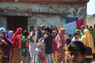 Bangladeş gecekondu halkı, 29 Mart 2020 'de Bangladeş' in Dhaka kentindeki COVID-19 coronavirüsüne karşı önleyici bir tedbir olarak hükümet tarafından uygulanan tecrit sırasında gecekondu mahallesinde yürüyor.