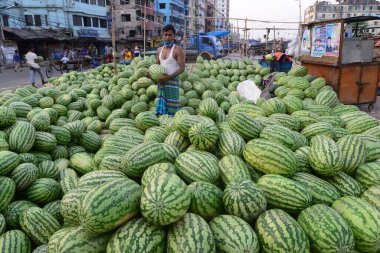 Bangladeşli karpuz satıcısı, 8 Nisan 2020 'de Bangladeş' in Dhaka kentindeki COVID-19 coronavirüsüne karşı önleyici bir tedbir olarak hükümet tarafından kapatılırken bir mutfak pazarında müşteri bekliyor.. 