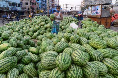 Bangladeşli karpuz satıcısı, 8 Nisan 2020 'de Bangladeş' in Dhaka kentindeki COVID-19 coronavirüsüne karşı önleyici bir tedbir olarak hükümet tarafından kapatılırken bir mutfak pazarında müşteri bekliyor.. 