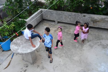 25 Mayıs 2020 'de Bangladeş' in Dhaka kentindeki COVID-19 koronavirüsüne karşı önleyici bir tedbir olarak hükümet tarafından tecrit altına alınan bir binanın çatısında Kurban Bayramı kutlamaları için oynayan Müslüman çocuklar.