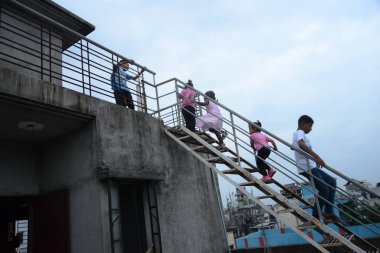 25 Mayıs 2020 'de Bangladeş' in Dhaka kentindeki COVID-19 koronavirüsüne karşı önleyici bir tedbir olarak hükümet tarafından tecrit altına alınan bir binanın çatısında Kurban Bayramı kutlamaları için oynayan Müslüman çocuklar.