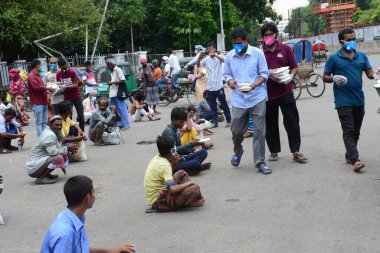 Bangladeş, Dhaka 'daki Dhaka Üniversitesi Kampüsü bölgesinde 3 Haziran 2020' de meydana gelen koronavirüs salgını sırasında evsizler arasında gıda dağıtımı yapan Dhaka Üniversitesi öğrencileri. 