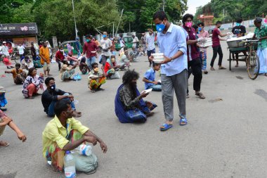Bangladeş, Dhaka 'daki Dhaka Üniversitesi Kampüsü bölgesinde 3 Haziran 2020' de meydana gelen koronavirüs salgını sırasında evsizler arasında gıda dağıtımı yapan Dhaka Üniversitesi öğrencileri. 