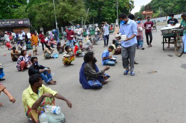 Bangladeş, Dhaka 'daki Dhaka Üniversitesi Kampüsü bölgesinde 3 Haziran 2020' de meydana gelen koronavirüs salgını sırasında evsizler arasında gıda dağıtımı yapan Dhaka Üniversitesi öğrencileri. 
