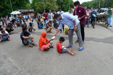 Bangladeş, Dhaka 'daki Dhaka Üniversitesi Kampüsü bölgesinde 3 Haziran 2020' de meydana gelen koronavirüs salgını sırasında evsizler arasında gıda dağıtımı yapan Dhaka Üniversitesi öğrencileri. 