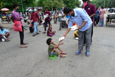 Bangladeş, Dhaka 'daki Dhaka Üniversitesi Kampüsü bölgesinde 3 Haziran 2020' de meydana gelen koronavirüs salgını sırasında evsizler arasında gıda dağıtımı yapan Dhaka Üniversitesi öğrencileri. 