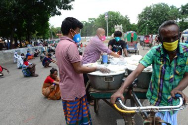 Bangladeş, Dhaka 'daki Dhaka Üniversitesi Kampüsü bölgesinde 3 Haziran 2020' de meydana gelen koronavirüs salgını sırasında evsizler arasında gıda dağıtımı yapan Dhaka Üniversitesi öğrencileri. 