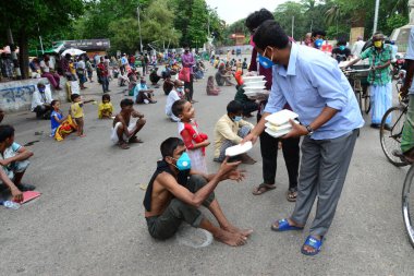 Bangladeş, Dhaka 'daki Dhaka Üniversitesi Kampüsü bölgesinde 3 Haziran 2020' de meydana gelen koronavirüs salgını sırasında evsizler arasında gıda dağıtımı yapan Dhaka Üniversitesi öğrencileri. 