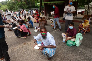 Bangladeş, Dhaka 'daki Dhaka Üniversitesi Kampüsü bölgesinde 3 Haziran 2020' de meydana gelen koronavirüs salgını sırasında evsizler arasında gıda dağıtımı yapan Dhaka Üniversitesi öğrencileri. 