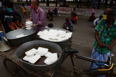 Bangladeş, Dhaka 'daki Dhaka Üniversitesi Kampüsü bölgesinde 3 Haziran 2020' de meydana gelen koronavirüs salgını sırasında evsizler arasında gıda dağıtımı yapan Dhaka Üniversitesi öğrencileri. 