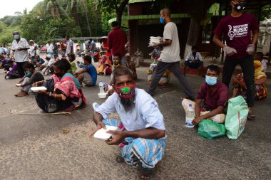 Bangladeş, Dhaka 'daki Dhaka Üniversitesi Kampüsü bölgesinde 3 Haziran 2020' de meydana gelen koronavirüs salgını sırasında evsizler arasında gıda dağıtımı yapan Dhaka Üniversitesi öğrencileri. 