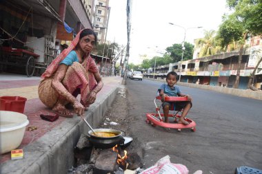 Bangladeş 'in Dhaka kentindeki COVID-19 Coronavirüsüne karşı 10 Nisan 2020' de hükümet tarafından tecrit altına alınırken sokakta yemek pişiren evsiz bir kadın.