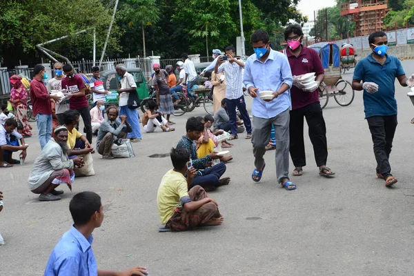 Bangladeş, Dhaka 'daki Dhaka Üniversitesi Kampüsü bölgesinde 3 Haziran 2020' de meydana gelen koronavirüs salgını sırasında evsizler arasında gıda dağıtımı yapan Dhaka Üniversitesi öğrencileri. 