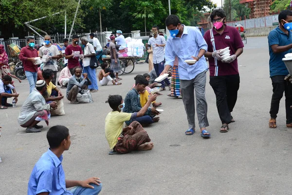 Bangladeş, Dhaka 'daki Dhaka Üniversitesi Kampüsü bölgesinde 3 Haziran 2020' de meydana gelen koronavirüs salgını sırasında evsizler arasında gıda dağıtımı yapan Dhaka Üniversitesi öğrencileri. 