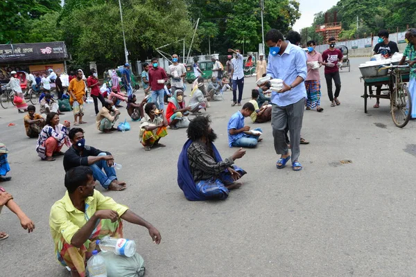 Bangladeş, Dhaka 'daki Dhaka Üniversitesi Kampüsü bölgesinde 3 Haziran 2020' de meydana gelen koronavirüs salgını sırasında evsizler arasında gıda dağıtımı yapan Dhaka Üniversitesi öğrencileri. 