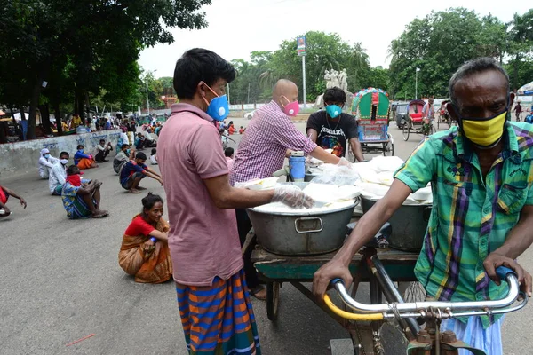 Bangladeş, Dhaka 'daki Dhaka Üniversitesi Kampüsü bölgesinde 3 Haziran 2020' de meydana gelen koronavirüs salgını sırasında evsizler arasında gıda dağıtımı yapan Dhaka Üniversitesi öğrencileri. 