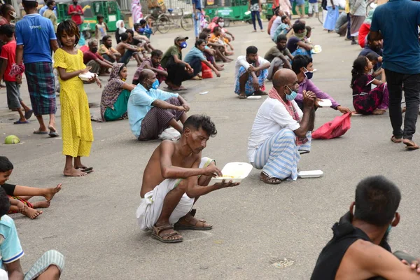 Bangladeş, Dhaka 'daki Dhaka Üniversitesi Kampüsü bölgesinde 3 Haziran 2020' de meydana gelen koronavirüs salgını sırasında evsizler arasında gıda dağıtımı yapan Dhaka Üniversitesi öğrencileri. 