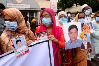 Akrabalar, 29 Ağustos 2020 'de Bangladeş' in Dhaka kentindeki Shahbagh bölgesinde, Uluslararası Kaybolma Günü öncesinde kayıp aile üyelerinin portrelerini tutuyor. İnsan zinciri mitingi Mayer Daak platformu tarafından düzenlenir.