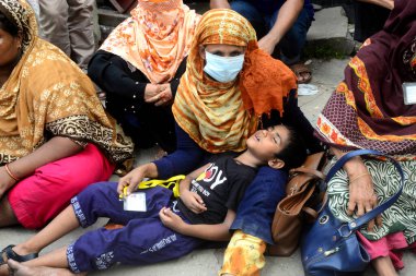 20 Eylül 2020 'de Dhaka, Bangladeş' te, İşçi Partisi binası önünde bir gösteri düzenleyen ve annesinin kucağında uyuyan bir çocuk görülüyor..