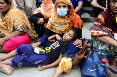 20 Eylül 2020 'de Dhaka, Bangladeş' te, İşçi Partisi binası önünde bir gösteri düzenleyen ve annesinin kucağında uyuyan bir çocuk görülüyor..