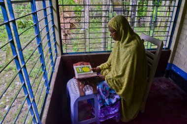 1 Ekim 2020 'de Jamalpur İlçesi, Bangladeş' teki evinde Müslüman bir kadın Al Kur 'an okur.