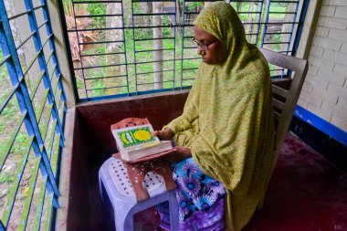1 Ekim 2020 'de Jamalpur İlçesi, Bangladeş' teki evinde Müslüman bir kadın Al Kur 'an okur.