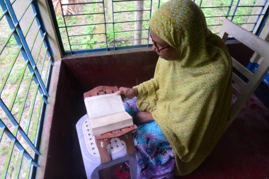 1 Ekim 2020 'de Jamalpur İlçesi, Bangladeş' teki evinde Müslüman bir kadın Al Kur 'an okur.