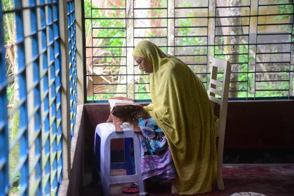 1 Ekim 2020 'de Jamalpur İlçesi, Bangladeş' teki evinde Müslüman bir kadın Al Kur 'an okur.