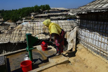 Bir Rohingyalı mülteci kadın Ukhia, Cox 's Bazar, Bangladeş' teki Balukhali mülteci kampındaki tüp kuyusundan su topluyor. Şubat 02, 2019