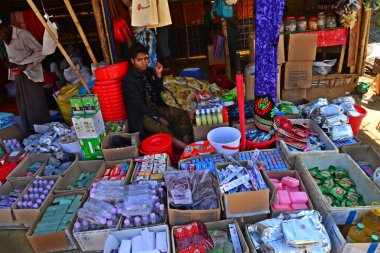 Rohingya mülteci dükkânı sahibi, Ukhia, Cox 's Bazar, Bangladeş' teki Balukhali mülteci kampının yanında ticaret yapmak için geçici bir iş piyasası kurulması için satış ürünlerini bekliyor. Şubat 02, 2019