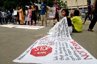 10 Ekim 2020 'de Dhaka' nın Noakhali ilçesinde bir kadına toplu tecavüz ve işkence yapıldığı iddiasıyla protesto sırasında sari yazılı tecavüz sloganı taşıyan Öğrenci Birliği eylemcisi. 