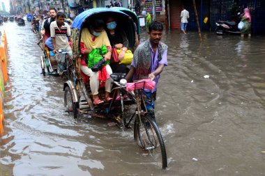 Araçlar sürmeye çalışıyor ve vatandaşlar 12 Ekim 2020 'de Bangladeş' teki Dhaka caddelerinde yürüyorlar. Şiddetli muson yağmurları Dhaka şehrinin birçok bölgesinde aşırı su kütüklerine neden oldu., 