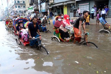 Araçlar sürmeye çalışıyor ve vatandaşlar 12 Ekim 2020 'de Bangladeş' teki Dhaka caddelerinde yürüyorlar. Şiddetli muson yağmurları Dhaka şehrinin birçok bölgesinde aşırı su kütüklerine neden oldu., 
