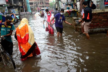 Araçlar sürmeye çalışıyor ve vatandaşlar 14 Ekim 2020 'de Bangladeş' teki Dhaka caddelerinde yürüyorlar. Şiddetli muson yağmurları Bangladeş 'in Dhaka şehrinin birçok bölgesinde aşırı su kütüklerine neden oldu. Yolculuk yaparken yollar sular altındaydı. 