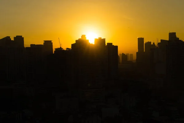 Orange color sunrise silhouette with city of Manila