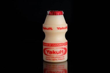 Manila Makati şehir, Filipinler. Mayıs 29 2019: Yakult siyah izole arka plan üzerinde süt içecek fermente. Bakteri suşu Lactobacillus paracasei Shirota ile sağlıklı probiyotik içecek.