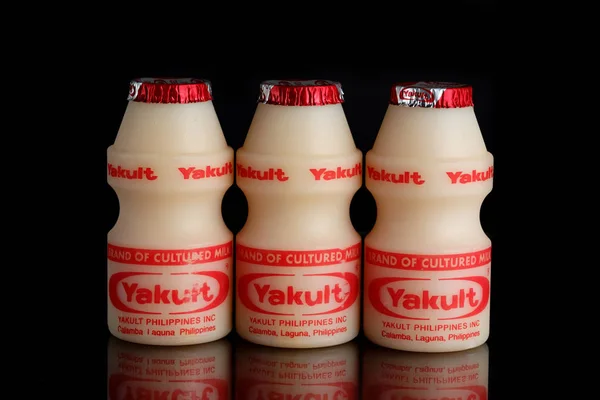 Manila Makati şehir, Filipinler. Mayıs 29 2019: Yakult siyah izole arka plan üzerinde süt içecek fermente. Bakteri suşu Lactobacillus paracasei Shirota ile sağlıklı probiyotik içecek.