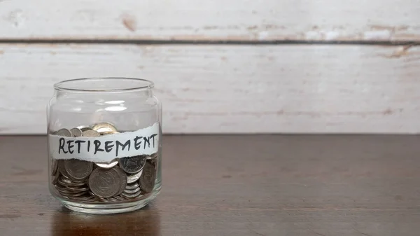 Save money for retirement concept with glass jar and coins.