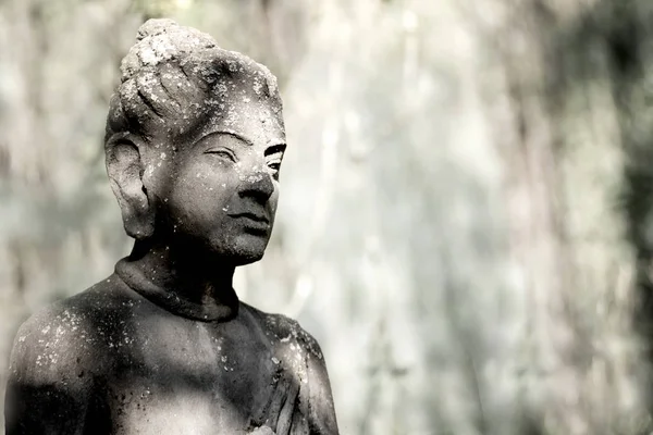 Stone statue of the Japanese Buddha in nature. Stone statue in black and white colour.