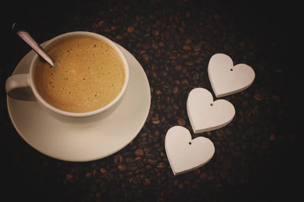 Coffee cup with beans, hearts and shine — Stock Photo, Image