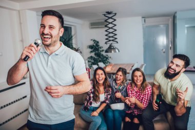 Grup Genç arkadaşlar evde karaoke oynarken