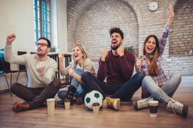TV'de futbol izlerken ve evde zaferini kutluyor genç arkadaşlar